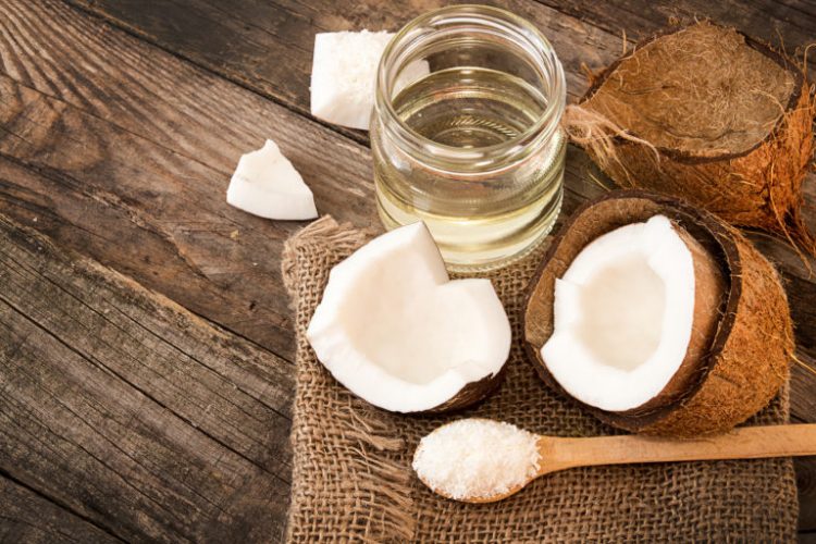 Half of coconut pieces of coconut coconut flakes and coconut glaas jar on wooden background. Healthy food concept